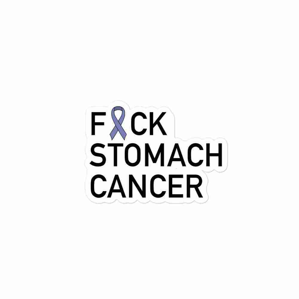 A sticker of text reading "Fuck Stomach Cancer" with the U censored with a periwinkle awareness ribbon.