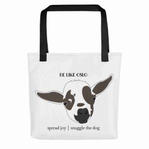 A white tote bag with a black strap, printed with a graphic of Oslo the goat, and the text "spread joy, snuggle the dog".