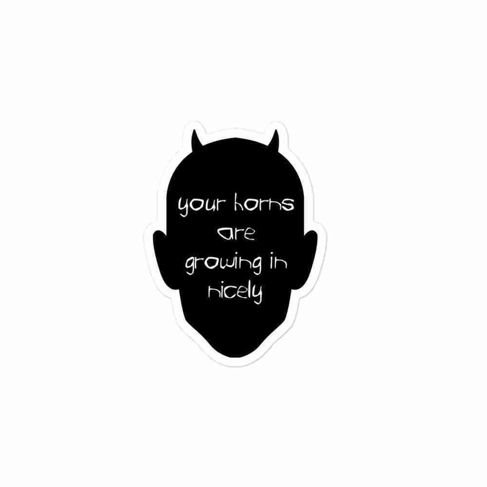 A sticker of a silhouetted head with small horns. Text inside reads "your horns are growing in nicely".